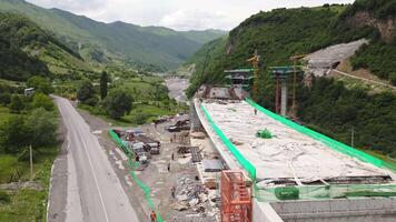 Kazbegi, Georgia - 7th july, 2024 - aerial view cranes and bridge foundation pillars on construction site of new highway road project built by chinese builders.Avalanche bypass tunnel.Tbillisi - Lars video