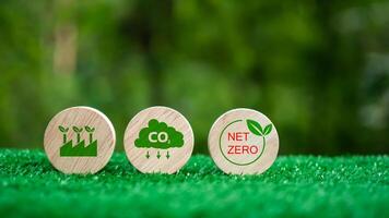 Three wooden circles with a green background and the words CO2, Net Zero. CO2 emission reduction concept, Clean environment without carbon dioxide emissions, Environmental protection concept. photo