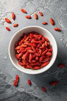 Bowl of dried goji berries emphasizing the vibrant red color and texture of the berries. photo