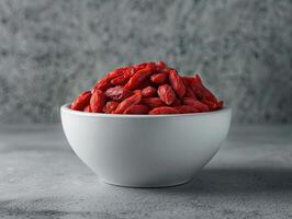 Bowl of dried goji berries emphasizing the vibrant red color and texture of the berries. photo