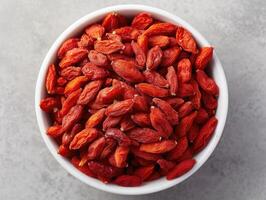 Bowl of dried goji berries emphasizing the vibrant red color and texture of the berries. photo