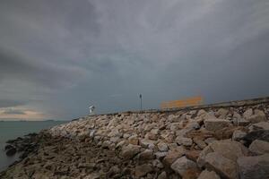 A rock wall extending into the sea photo