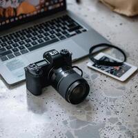 Photographer's workplace on a white background. Camera Beside a Laptop. photo