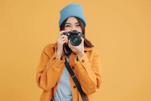 woman holding camera on solid bright background. photo