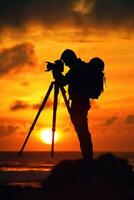 man hold camera on the cliff of the mountain on sunset background, photo
