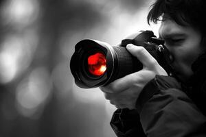 man hand holding camera looking through lens. photo