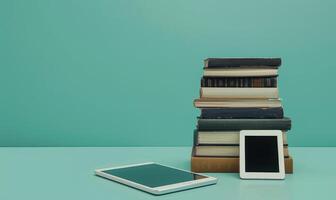 Stack of books on a light gray table with a pastel turquoise background photo
