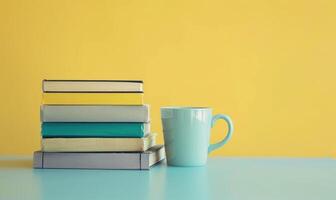Stack of books on a light gray table with a pastel butter yellow background photo