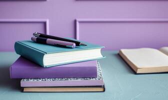 Stack of books on a glass table with a pastel violet background photo