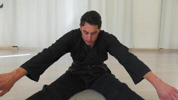 Man Does Stretching In Gym With Karate Uniform video