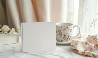 White blank card in a ceramic white frame on a pastel ivory table photo