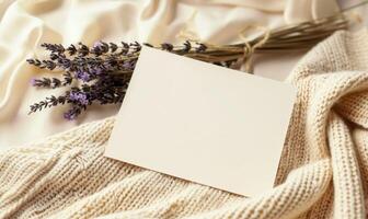 White blank card in a delicate lace frame on a pastel butter yellow table, with a knitted cloth and a small lavender bunch photo