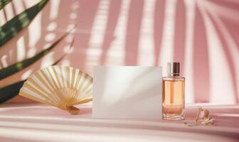 White blank card on a pastel pink table, with a delicate hand fan and a small perfume bottle photo