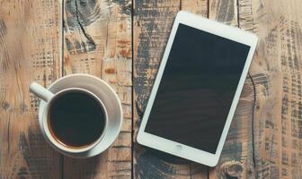 Tablet on a light gray table with a cup of tea on the left, sunlight from window photo