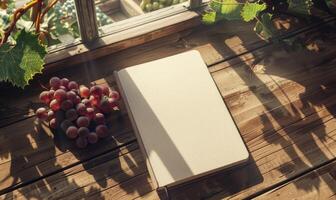 Notebook on a wooden table with a bunch of grapes photo