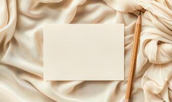 White blank card on a pastel cream background, with a piece of linen cloth and a handmade candle photo