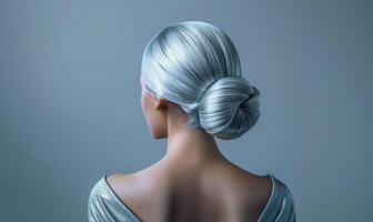 A woman with silver hair, styled in a sleek chignon, back view photo