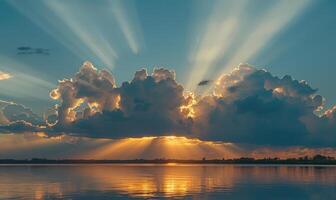 The sun peeking through a fluffy cumulus clouds, clouds reflected in water surface, sunset on the lake photo