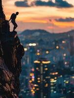 man climbing on the edge of a cliff at sunset photo