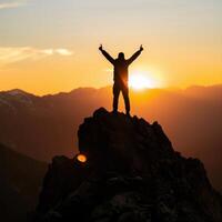 a man standing on top of a mountain with his arms raised photo