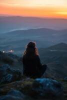 a person sitting on a rock photo