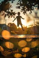 a child jumping on a trampoline at sunset photo
