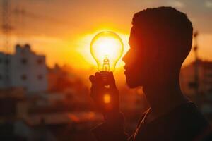 a man holding a light bulb in his hand photo