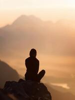 a person sitting on a rock overlooking the mountains photo