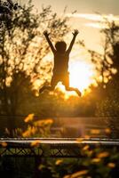 a child jumping on a trampoline at sunset photo