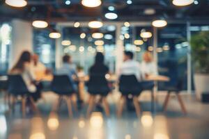 a blurry image of people sitting at a table in a conference room photo