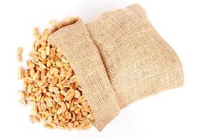peeled roasted peanuts in rustic bag isolated on white background photo