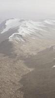 large snow patch left over on the volcanic rock field of a mountain in summer video