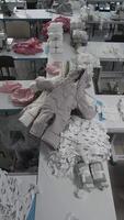 Workers in a textile factory are sewing and assembling garments in a production line video