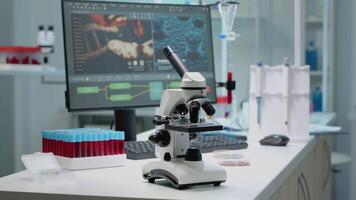Scientific microscope on laboratory desk with researching instruments at professional workplace. Close up of investigation tool with glass lens for chemical substance lab examination video