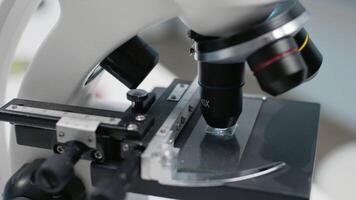 Close up of science laboratory microscope tray for sample testing at workplace. Optical microscopic instrument with magnifying lenses and glass tools for chemical dna and blood results video