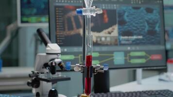 Close up of test tube and pipe for mixing solutions in laboratory on desk. Medical research equipment in glassware used on testing and chemistry experiment with microscope and computer video