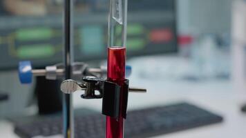 Close up of test tube with fluid blood or dna for experiment in scientific laboratory. Chemical dripping pipe and liquid flask on desk used for pharmaceutical testing and development video