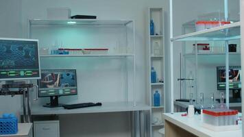 Nobody in laboratory space with chemical equipment for medical research and discovery. Empty room with vacutainers, bottles of pills, micropipette, computer and monitor for development video