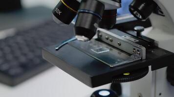 Close up of microscopic sample tray for optical analysis in laboratory. Microscope with magnifying lens used for dna and bacteria investigation in pharmaceutical research industry video