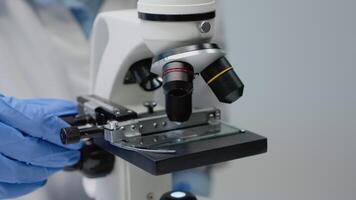 Sample tray of scientific microscope in laboratory used by doctor for biochemistry research. Optical instrument with glass lens and magnifier for dna expertise and development study video