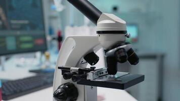 Close up of scientific microscope in laboratory using optical lens with magnifying glass for dna test on tray. Empty room with chemical equipment for sample and substance examination video