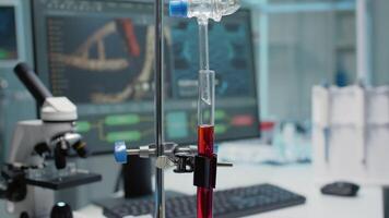 Close up of test tube and chemical dripping pipe in laboratory on desk. Medical equipment in glass flask used on mixing fluid. Microscope, computer and micropipette at scientific workplace video