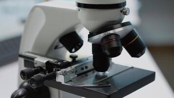 Close up of microscopic magnifying glass and lens used on blood sample in chemical laboratory. Researching equipment on desk. Science instruments and tools for scientific examination video