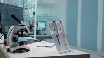 Close up of micro pipette tool and medical equipment in empty laboratory. Nobody in microbiology room with microscope, vacutainers and blood sample as research instruments on desk video