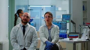 Team of researchers looking at virtual display with touchscreen, virtual reality using medical inovation in lab, gesticulating. Scientists working with equipment device, future, healthcare, vision, simulator video