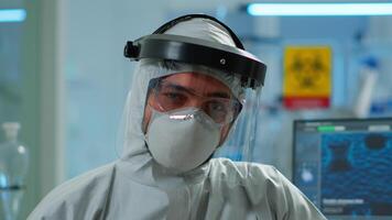 Close up of tired chemist man doctor in coverall working in scientific equipped laboratory. Scientist working with various bacteria, tissue and blood samples, pharmaceutical research for antibiotics video