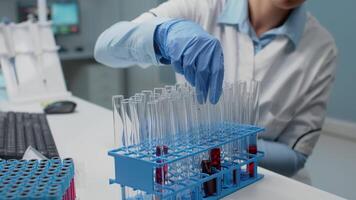 Portrait of laboratory scientist analyzing blood from test tube at chemical workplace. Medical researcher doing experiment using flask with red liquid substance. Woman studying for innovation video