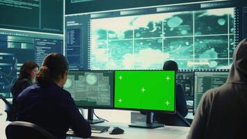 Hacking specialist works with an isolated chroma key display in high tech agency office, securing national servers with state secrets. Governmental hacker examines threat detection measures. Camera B. video