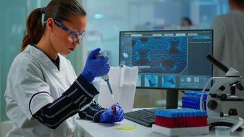 Research scientist using micropipette to extract blood sample on petri dish analysing chemical reaction sitting in laboratory. Doctor examining virus evolution using high tech and chemistry tools video