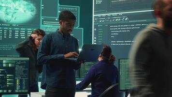 Group of governmental hackers analyzing digital threats on pc networks, using a big screen. Specialists working on collecting information, fighting against cybercrime and cyberterrorism. Camera A. video